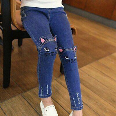 Child's legs wearing blue jeans with 3D cat faces on the knees, sitting in a chair -compressed-by-imagesharpify